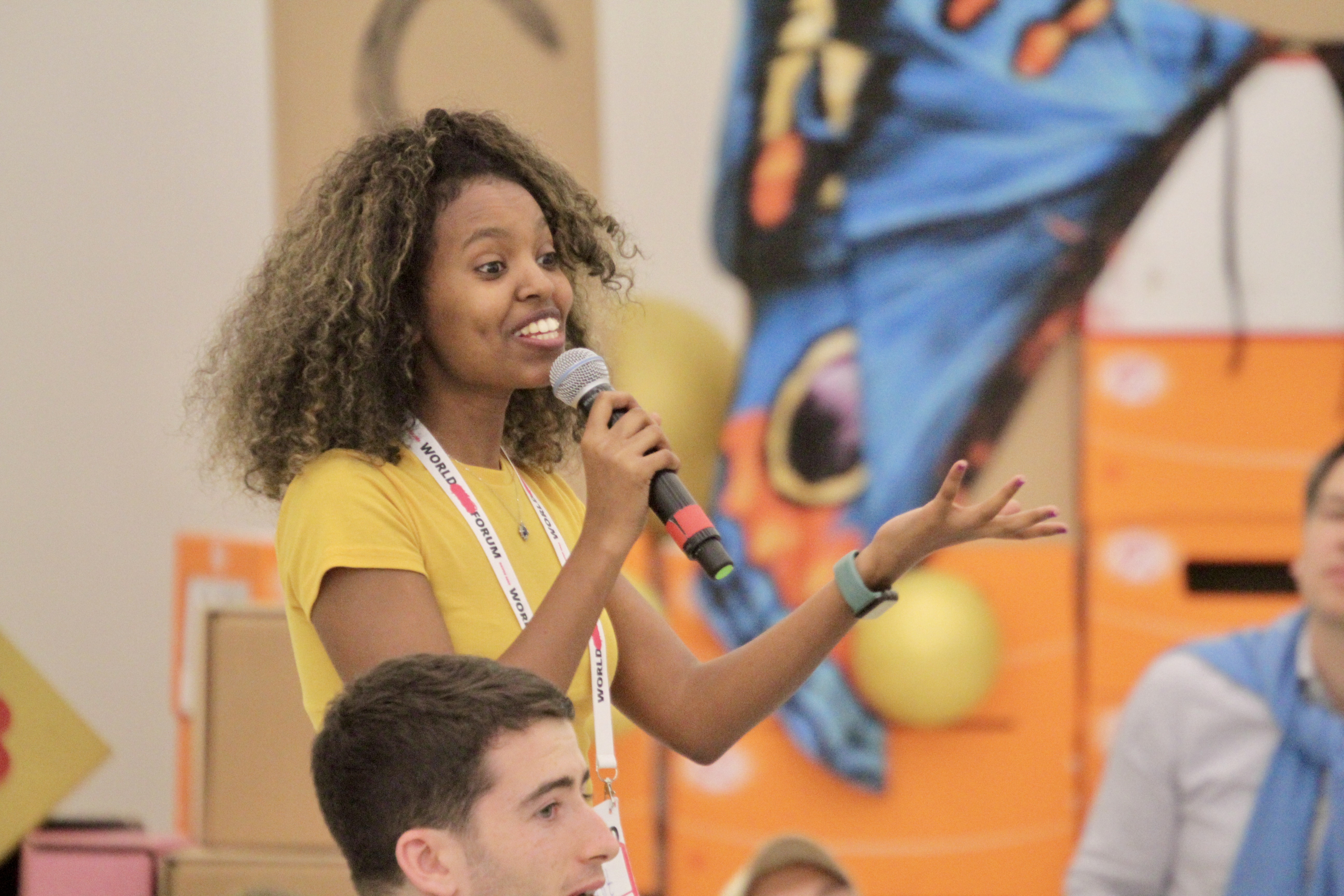 Das Foto zeigt eine Jugendliche, die beim World Child Forum spricht.