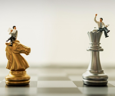 Die Grafik zeigt zwei Interim Manager, die auf Schachfiguren sitzen.