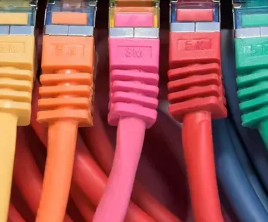 Interim Management IT: Das Bild zeigt Kabel in verschiedenen Farben, die angeschlossen sind.