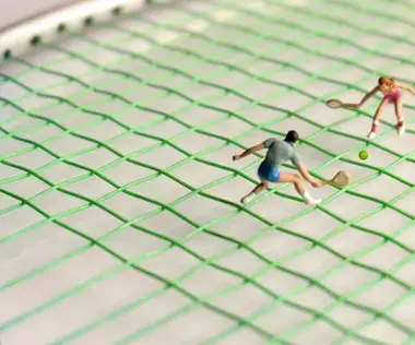 Coaching richtig planen: Das Bild zeigt Figuren, die auf einem Tennisschläger Tennis spielen.