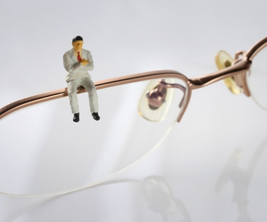 Kulturwandel: Das Bild zeigt eine Figur, die auf einem Brillengestell sitzt.