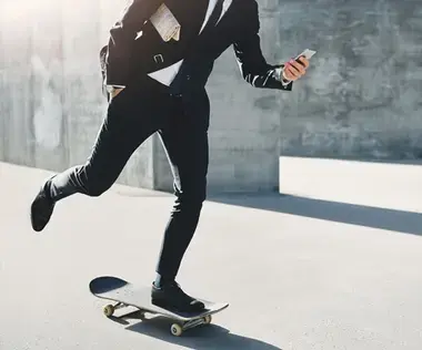 Interim Management Unternehemensführung: Das Bild zeigt einen Geschäftsmann auf einem Skateboard.