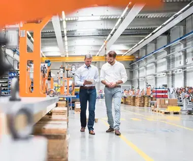 Interim Management Operations: Das Bild zeigt zwei Opreations Manager in einer Lagerhalle. 