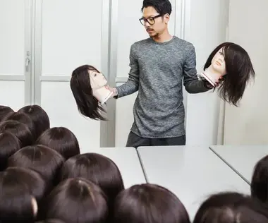 Interim Management Personalwesen: Das Bild zeigt einen Mann mit Perückenköpfe in beiden Händen und mit weiteren vor ihm. 