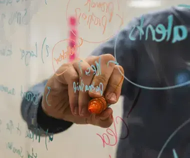 Interim Management: Das Bild zeigt, wie ein transparentes Whiteboard beschriftet wird. 