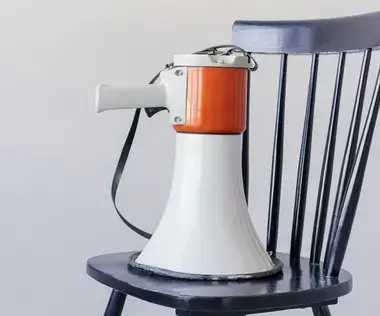 Interim Management Unternehmenskommunikation: Das Bild zeigt ein Megaphon auf einem Stuhl. 