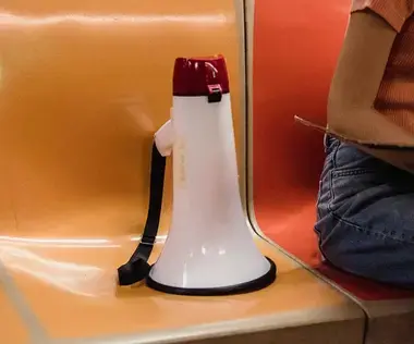 Interim Management Unternehmenskommunikation: Das Bild zeigt ein Megafon auf einem U-Bahn-Sitz. 