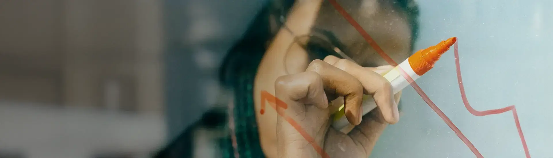 Interim Management Controlling: Das Bild zeigt eine Frau, die ein Diagramm auf ein transparentes Flipboard zeichnet.