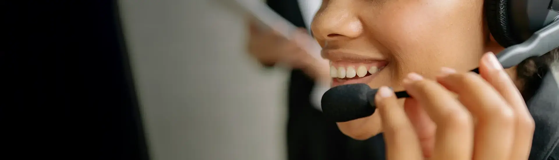 Interim Management Dienstleistungsbranche: Das Bild zeigt eine mit Headset telefonierende Frau.