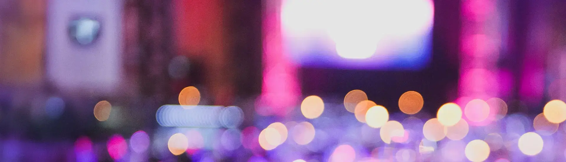 Interim Event Management: Das Bild zeigt eine verschwommen aufgenommene Bühne aus der Ferne.