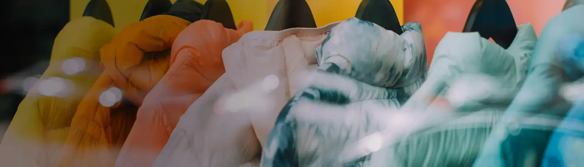 Interim Management Konsumgüter & FMCG: Das Bild zeigt farbige Jacken auf Kleiderbügeln.