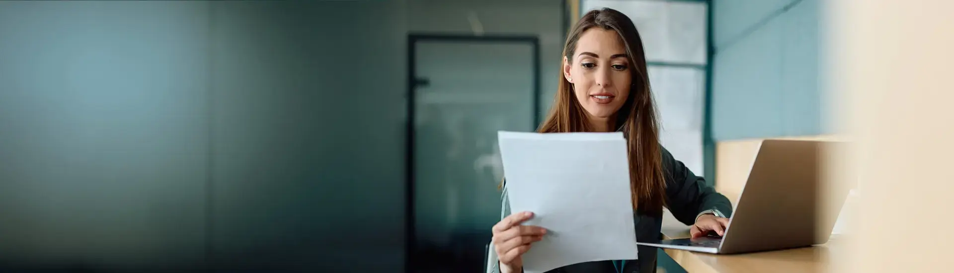 Interim Vertragsmanagement: Das Bild zeigt eine junge Anwältin, die einen Vertrag liest.