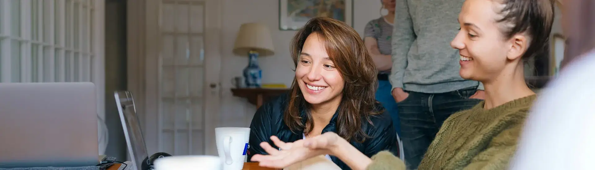 Interim Management Publikationen: Das Bild zeigt zwei junge Frauen, die auf einen Laptop schauen.