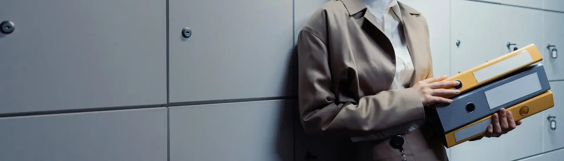 Interim Compliance Management: Das Bild zeigt Interim Managerin mit Aktenordnern in der Hand.