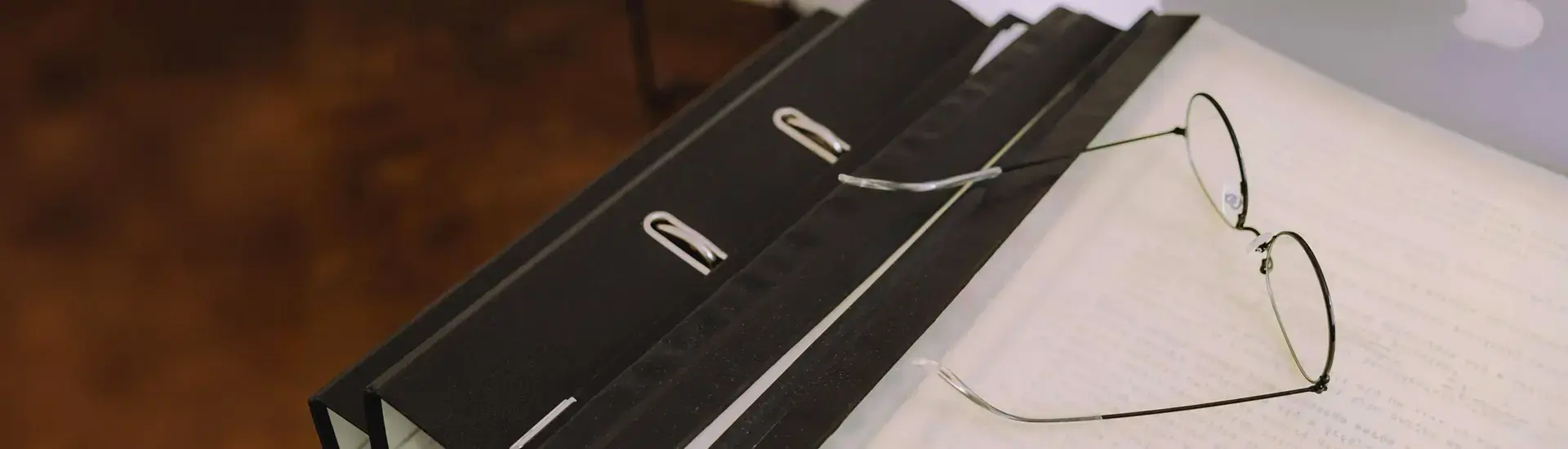 Interim Management Patentrecht: Das Bild zeigt eine Brille auf einem Aktenstabel liegend.