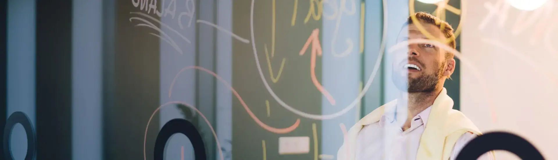 Interim Transformation Management: Das Bild zeigt einen Transformation Manager hinter einer beschriebenen Glaswand.