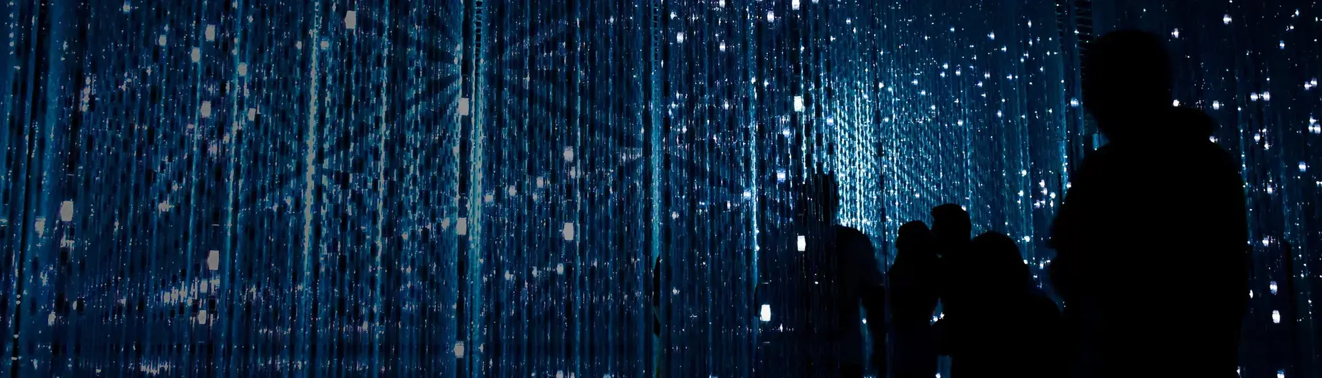 Interim Management IT: Das Bild zeigt Menschen vor einer blauen Datenwand.