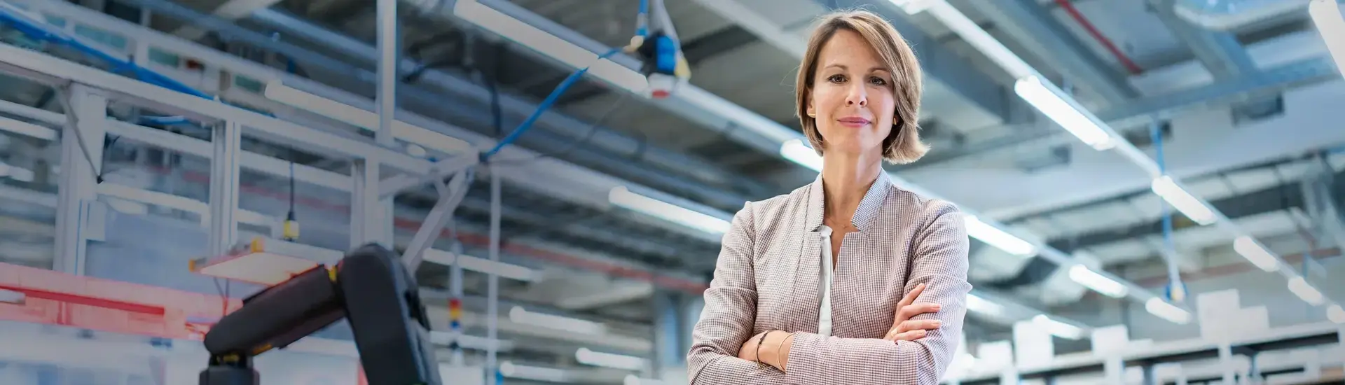 Das Bild zeigt eine Interim Operations Managerin in einer Fabrikhalle.