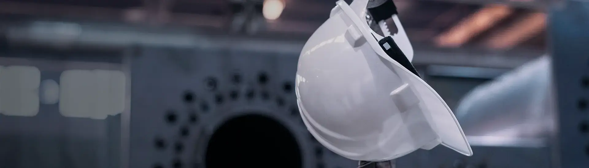 Produktionsverlagerung: Das Bild zeigt einen weissen Sicherheitshelm in einer Fabrikumgebung.