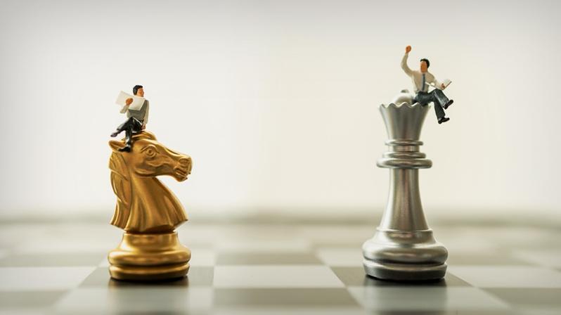 Die Grafik zeigt zwei Interim Manager, die auf Schachfiguren sitzen.