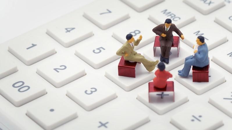 Digitales Reporting: Das Bild zeigt vier Figuren, die auf einer Tastatur sitzen.