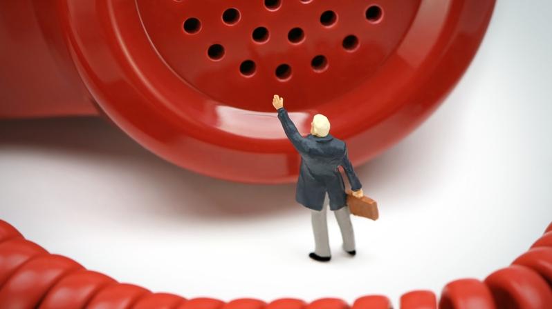 Feedback-Kultur für agile Organisationsentwicklung: Das Bild zeigt eine Figur vor einem roten Telefonhörer.