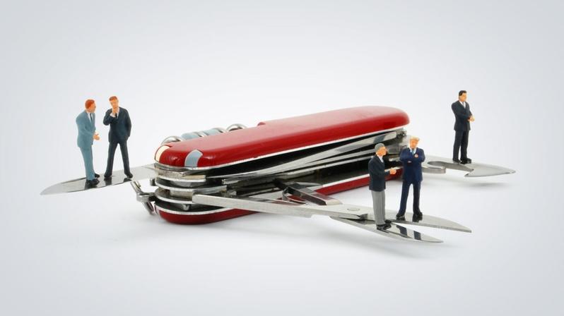 HR Shared Service Center: Das Bild zeigt mehrere Figuren, die um ein Schweizer Taschenmesser herumstehen.