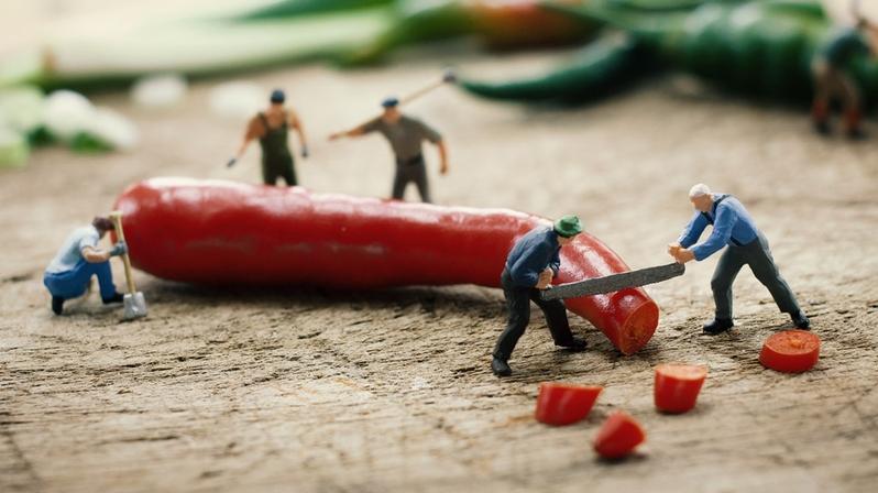 Versorgungssicherheit in Lieferketten schaffen: Das Bild zeigt Figuren, die eine Chili zersägen.