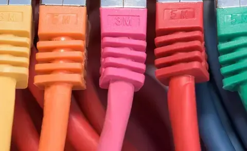 Interim Management IT: Das Bild zeigt Kabel in verschiedenen Farben, die angeschlossen sind.