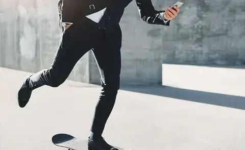 Interim Management Unternehemensführung: Das Bild zeigt einen Geschäftsmann auf einem Skateboard.