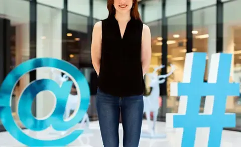 Interim Management Marketing: Das Bild zeigt eine Frau zwischen einem @-Zeichen und einem #-Zeichen