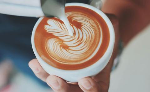Interim Management: Das Bild zeigt, wie ein Barista einen Cappuccino gekonnt zubereitet. 