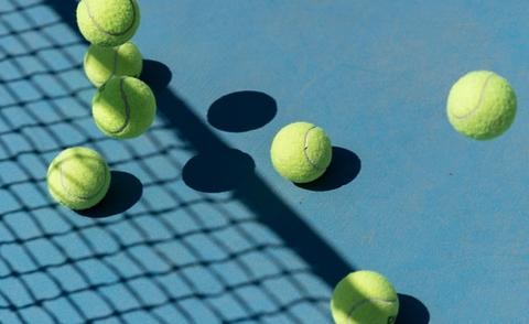 Interim Management: Das Bild zeigt einen Tennisplatz mit mehreren Tennisbällen. 