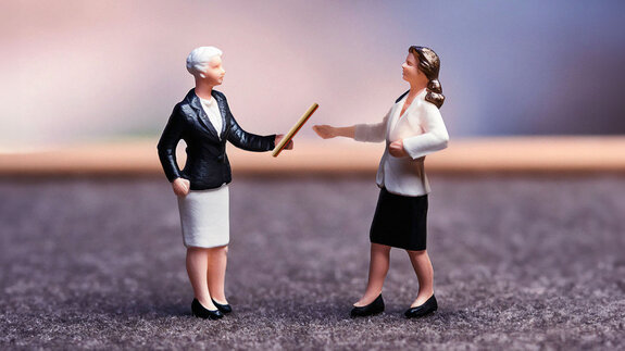 Eine Unternehmensinhaberin übergibt den Staffelstab an ihre Nachfolge.